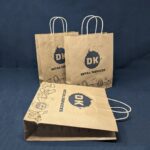 Affordable Durable Paper Bag from DK Retail, filled with assorted electronic items and accessories