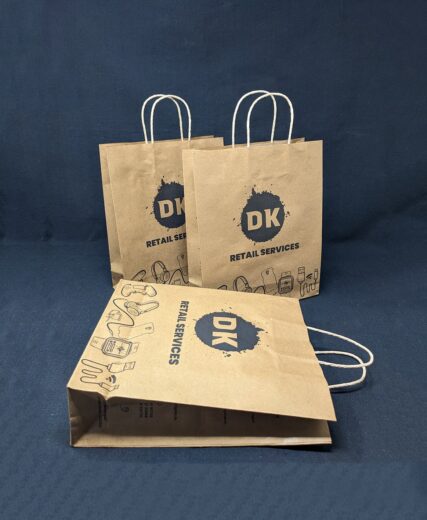 Affordable Durable Paper Bag from DK Retail, filled with assorted electronic items and accessories