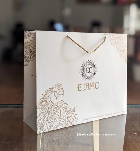 Ethinic Collective's customized paper bag with metallic gold logo, perfect for carrying your Parisian clothing finds