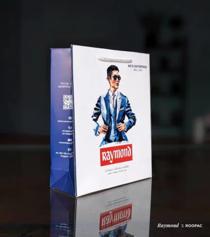 Impeccably tailored outfits, including shirts, trousers, blazers, and suits, elegantly carried in the Raymond paper bag, showcasing personalized style and attention to detail.