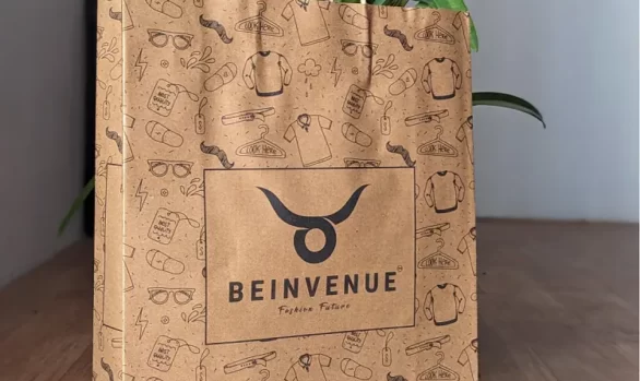 A stylish customer at "Bienvenue" Men's Clothing Store in Tiruppur holding a Roopac Durable Brown Kraft Bag.