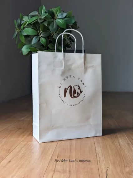 A customer carrying a Roopac printed paper bag from Dr. Neha Vani's Ojas Health Care.