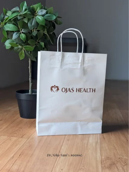 Close-up of a Roopac printed paper bag with Ojas Health Care's logo, a testament to the clinic's commitment to sustainability.