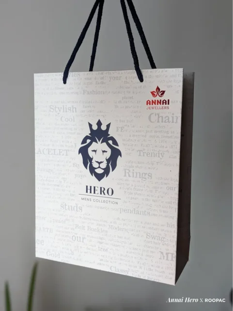 Hero - Mens Collection paper bag with Lion Face logo and red Annai Jewellers stamp at Thoothukudi, Kovilpatti, and Rajapalayam