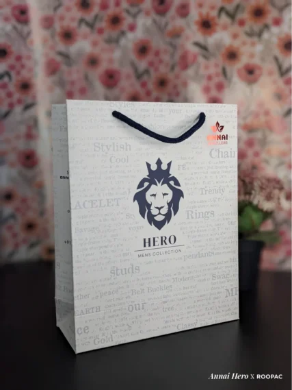 Hero - Mens Collection paper bag with Lion Face logo and red Annai Jewellers stamp at Thoothukudi, Kovilpatti, and Rajapalayam