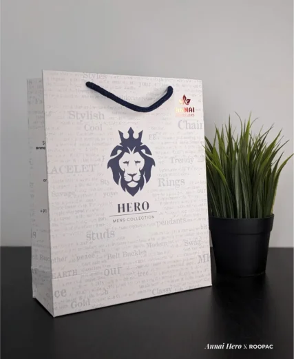 Hero - Mens Collection paper bag with Lion Face logo and red Annai Jewellers stamp at Thoothukudi, Kovilpatti, and Rajapalayam