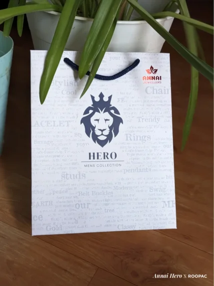 Hero - Mens Collection paper bag with Lion Face logo and red Annai Jewellers stamp at Thoothukudi, Kovilpatti, and Rajapalayam