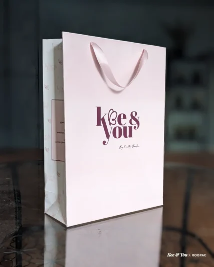 Kee & You baby pink paper bag with purple logo from Mysore