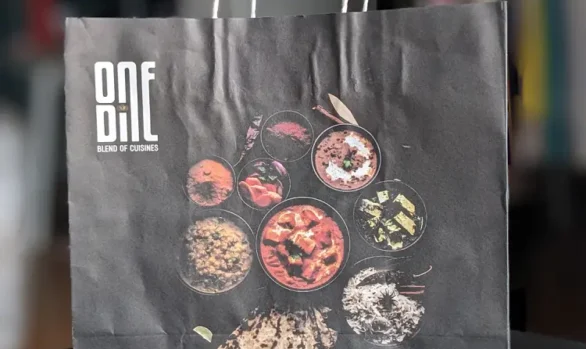 One Dine paper bag holding gourmet takeout food