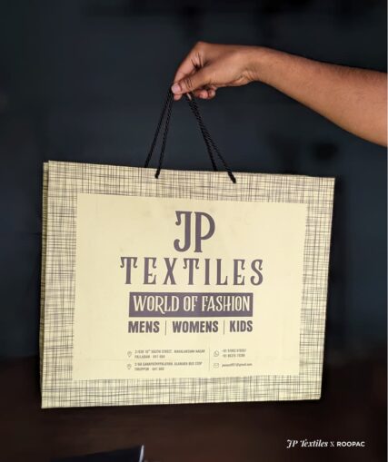 JP Textiles' fashionable light yellow and grey paper bag with thread pattern.