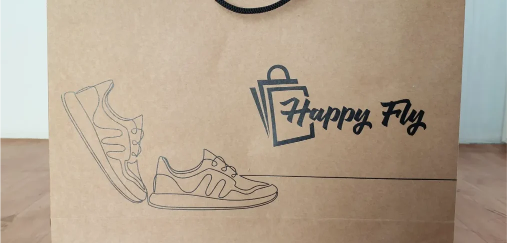Paper bag for premium packaging with Happy Fly logo and shoe art