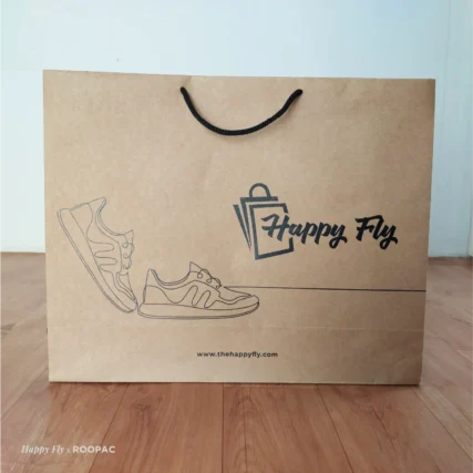 Paper bag for premium packaging with Happy Fly logo and shoe art
