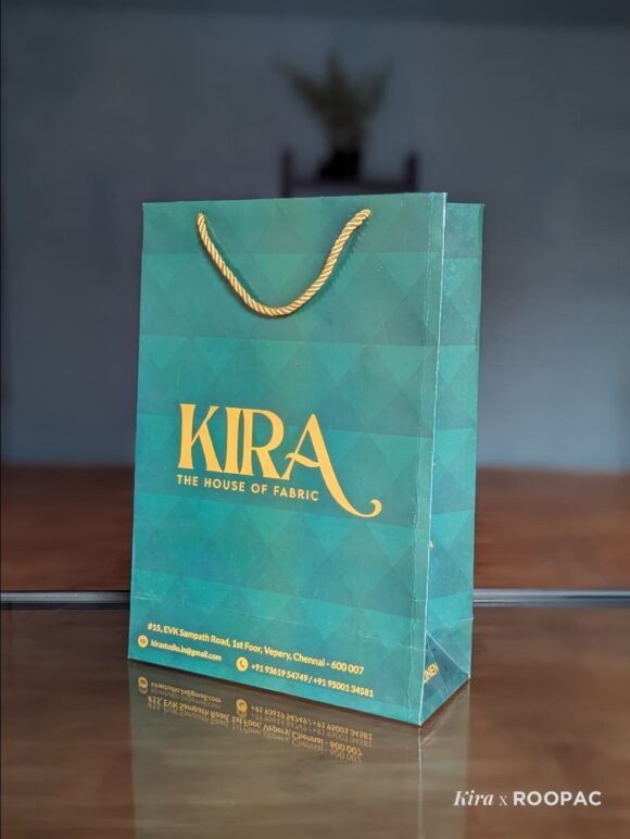 Dark blue paper bag with gold Kira logo for fabric store